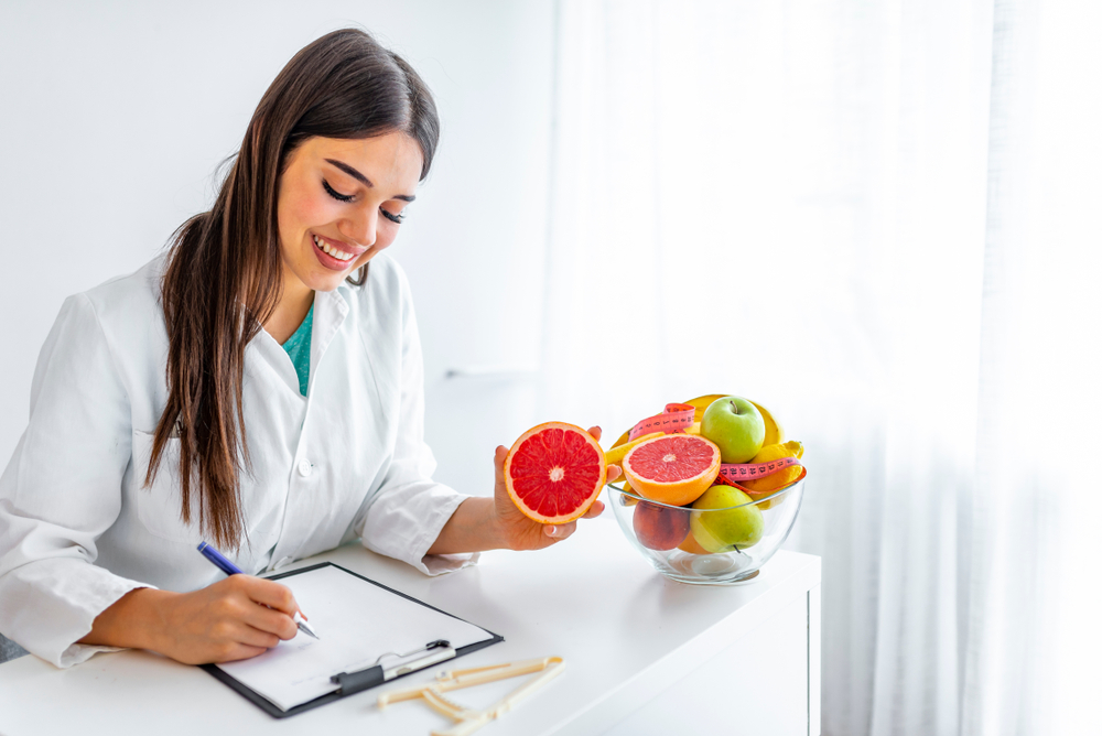 woman nutritionist documenting fruit for meal plan for client